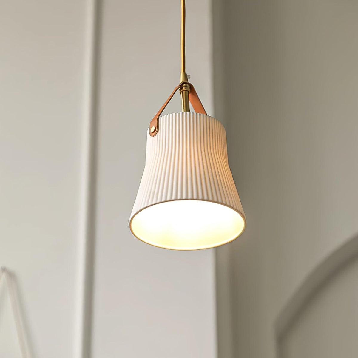 Moderne hanglamp met keramische geribbelde kap, messing en leerband