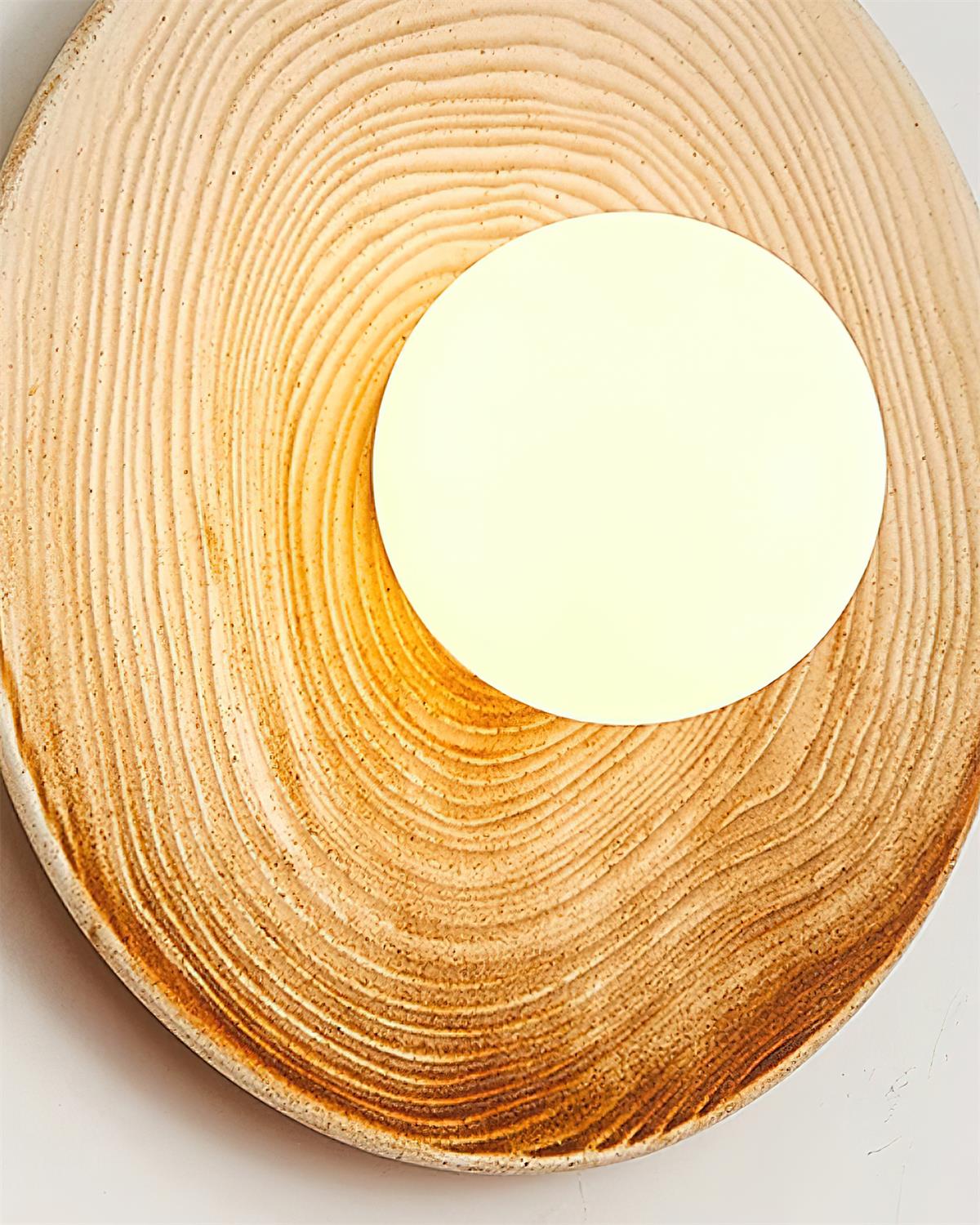 Moderne wandlamp met textuurkeramische schijf en houten accent voor entrees