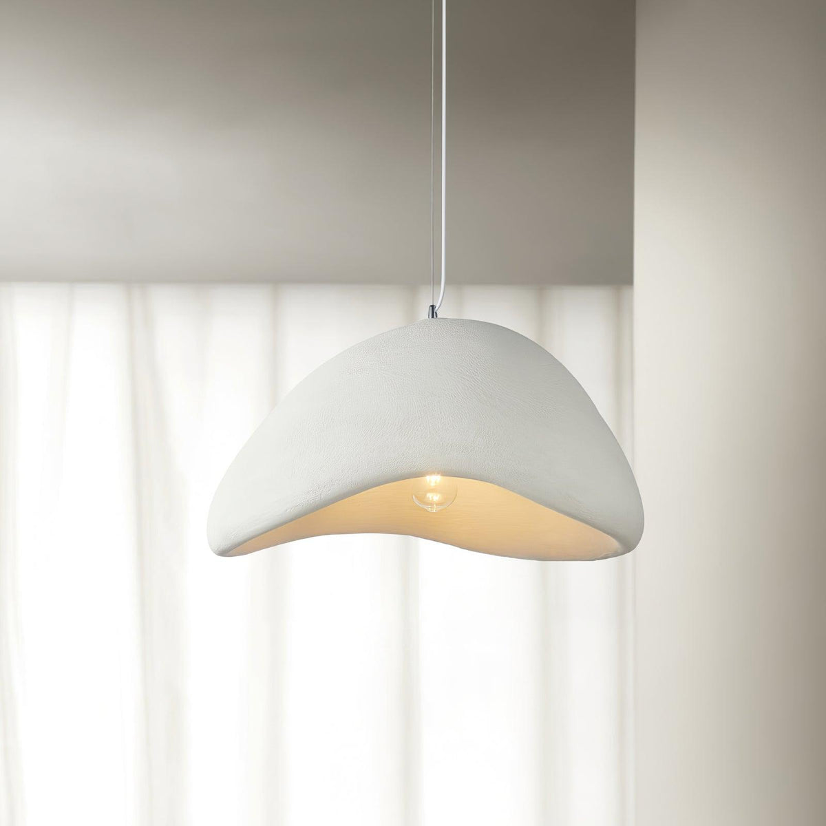 Moderne hanglamp met organische gebogen kap, zachte textuur en artistiek ontwerp