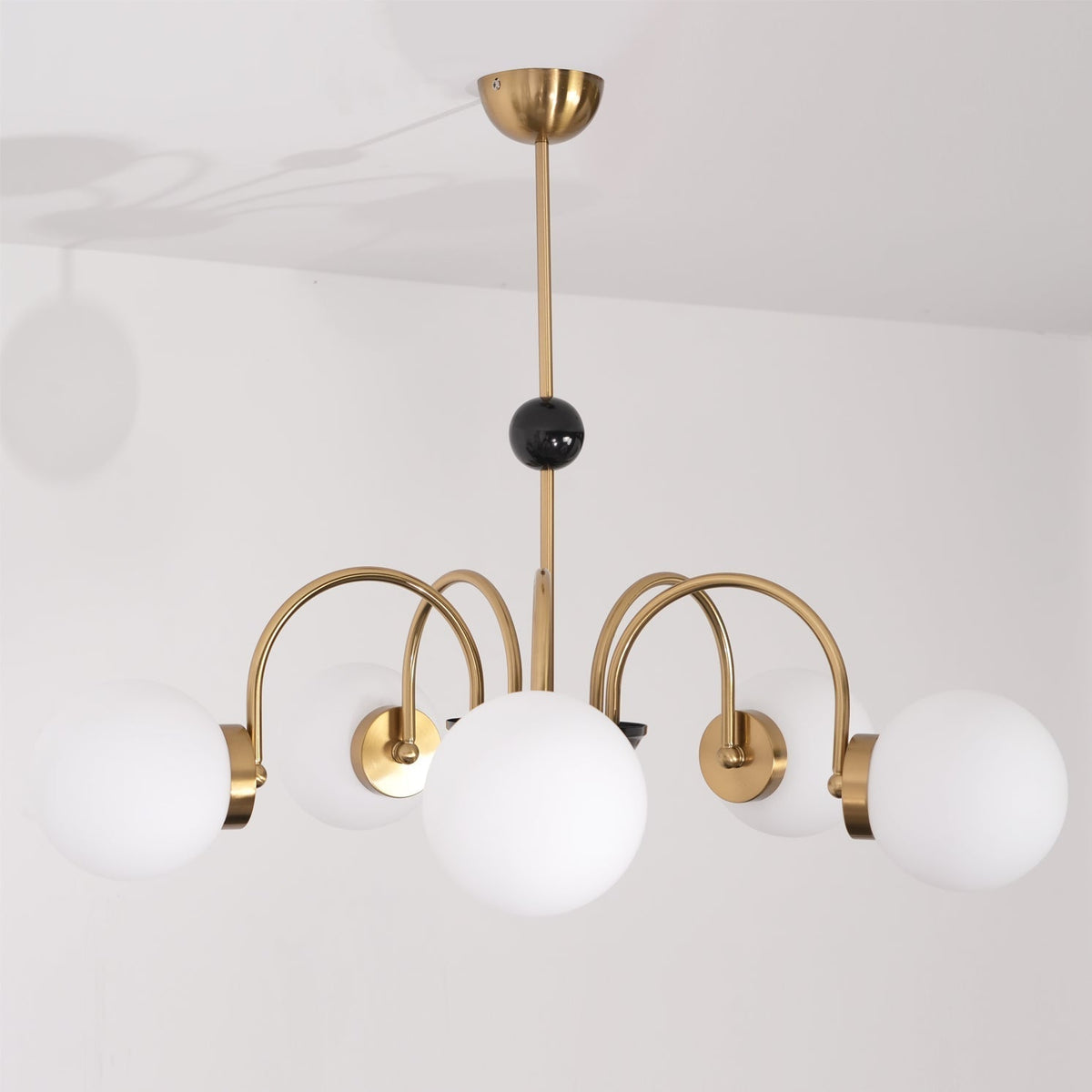 Moderne kroonluchter met gebogen armen en bolvormige kapjes, retro stijl voor eetkamer