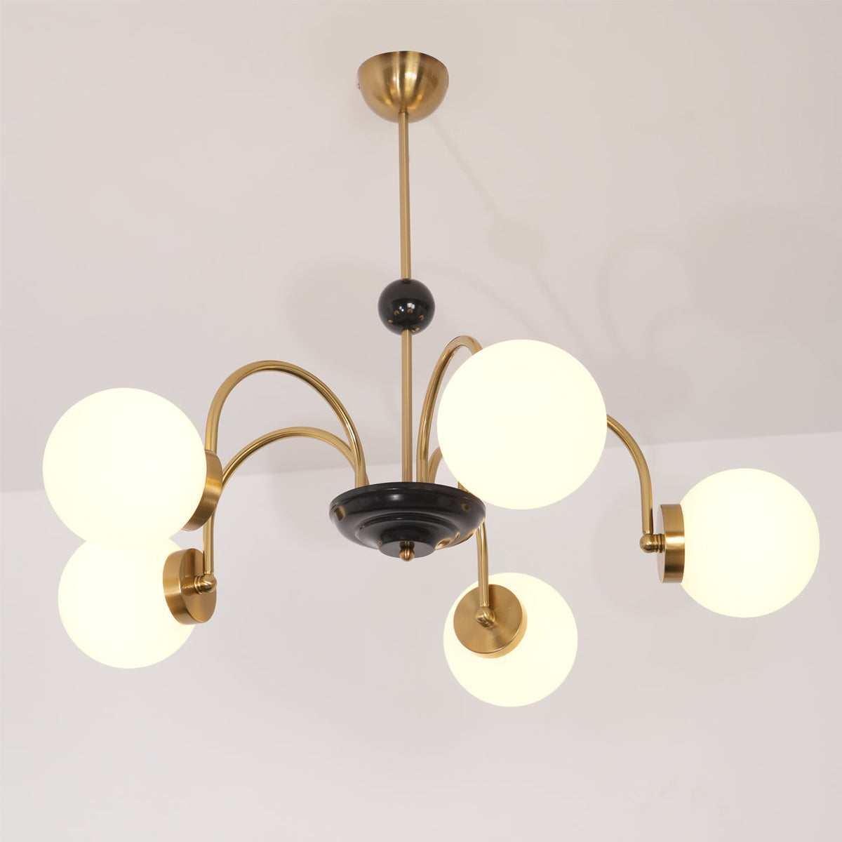 Moderne kroonluchter met gebogen armen en bolvormige kapjes, retro stijl voor eetkamer