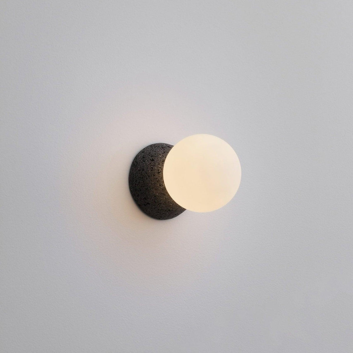 Eirinise wandlamp van beton en melkglas