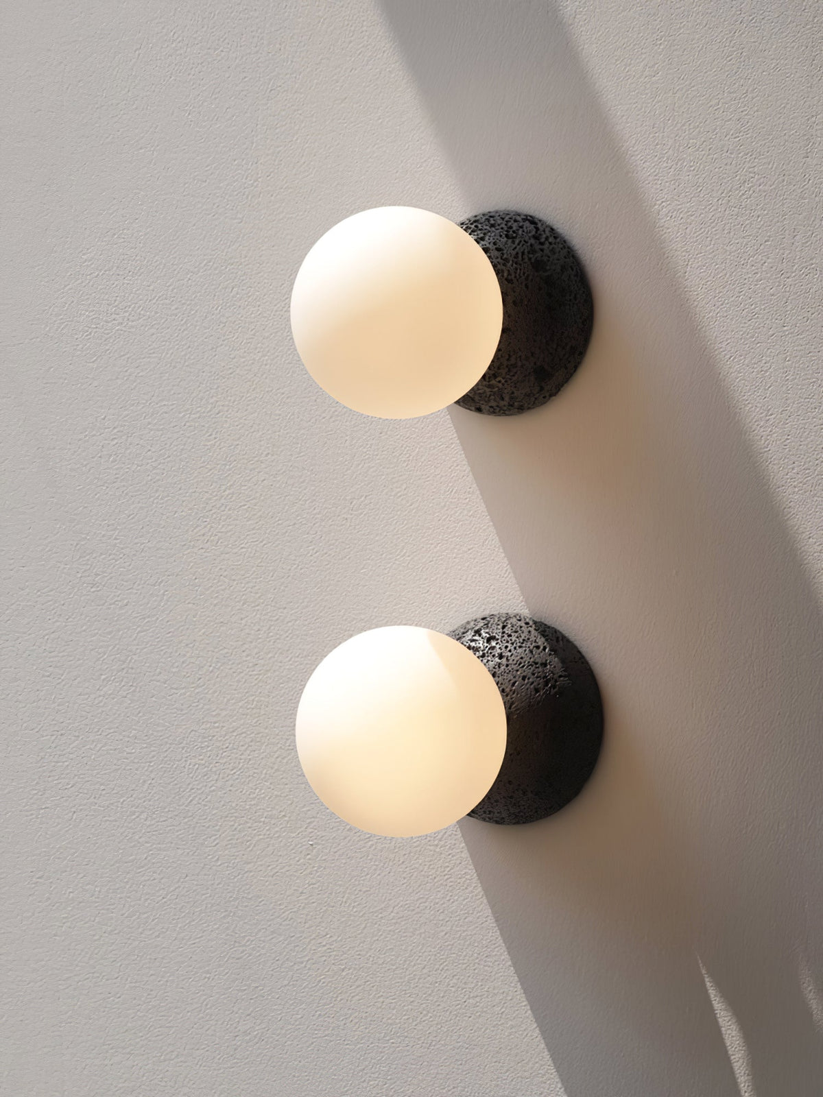Eirinise wandlamp van beton en melkglas