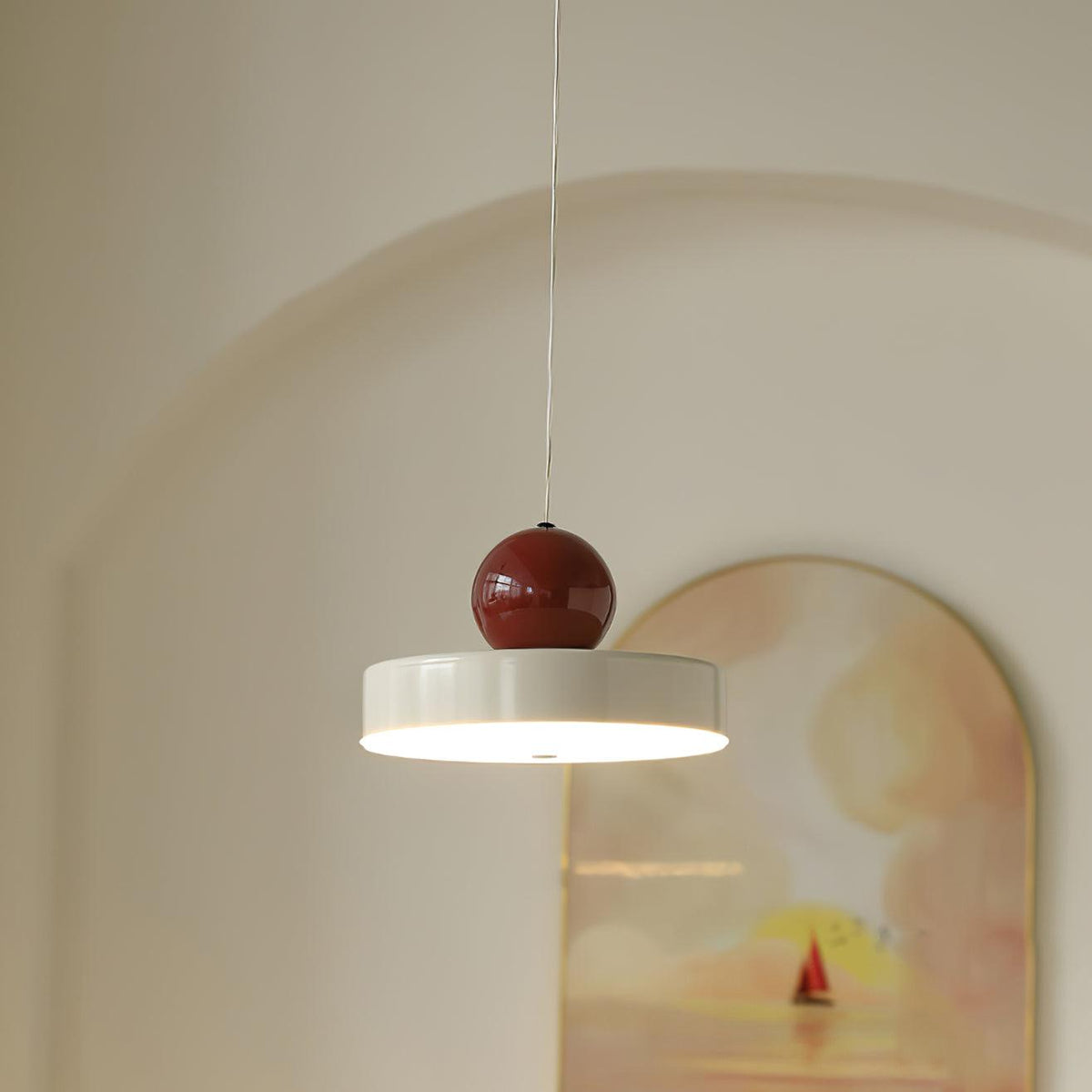 Moderne hanglamp met metalen behuizing, rode bolvormige kap en retro accent