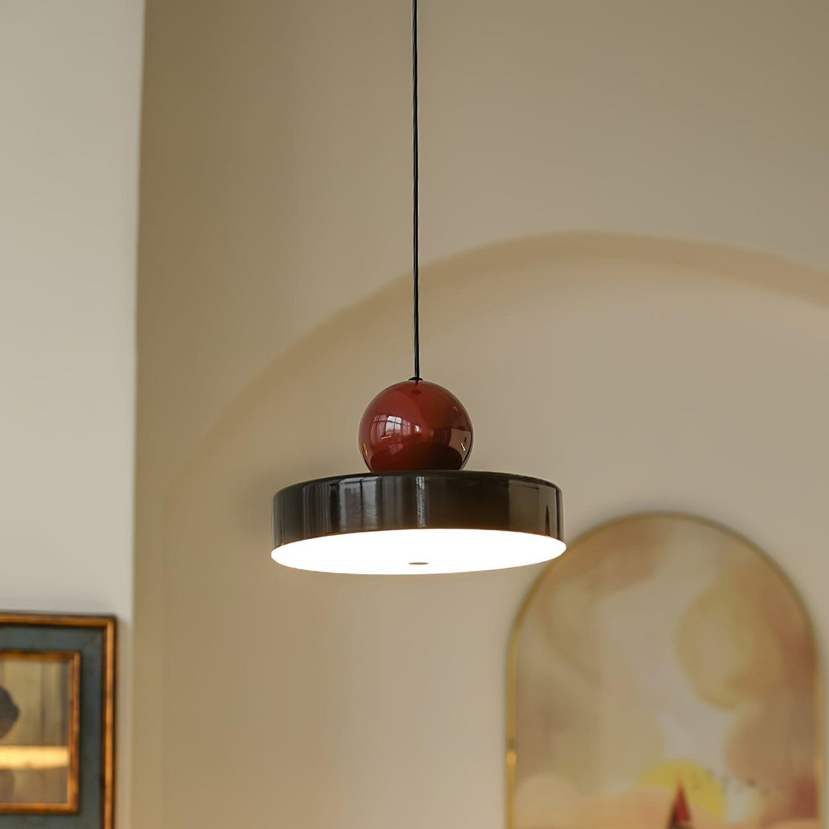 Moderne hanglamp met metalen behuizing, rode bolvormige kap en retro accent