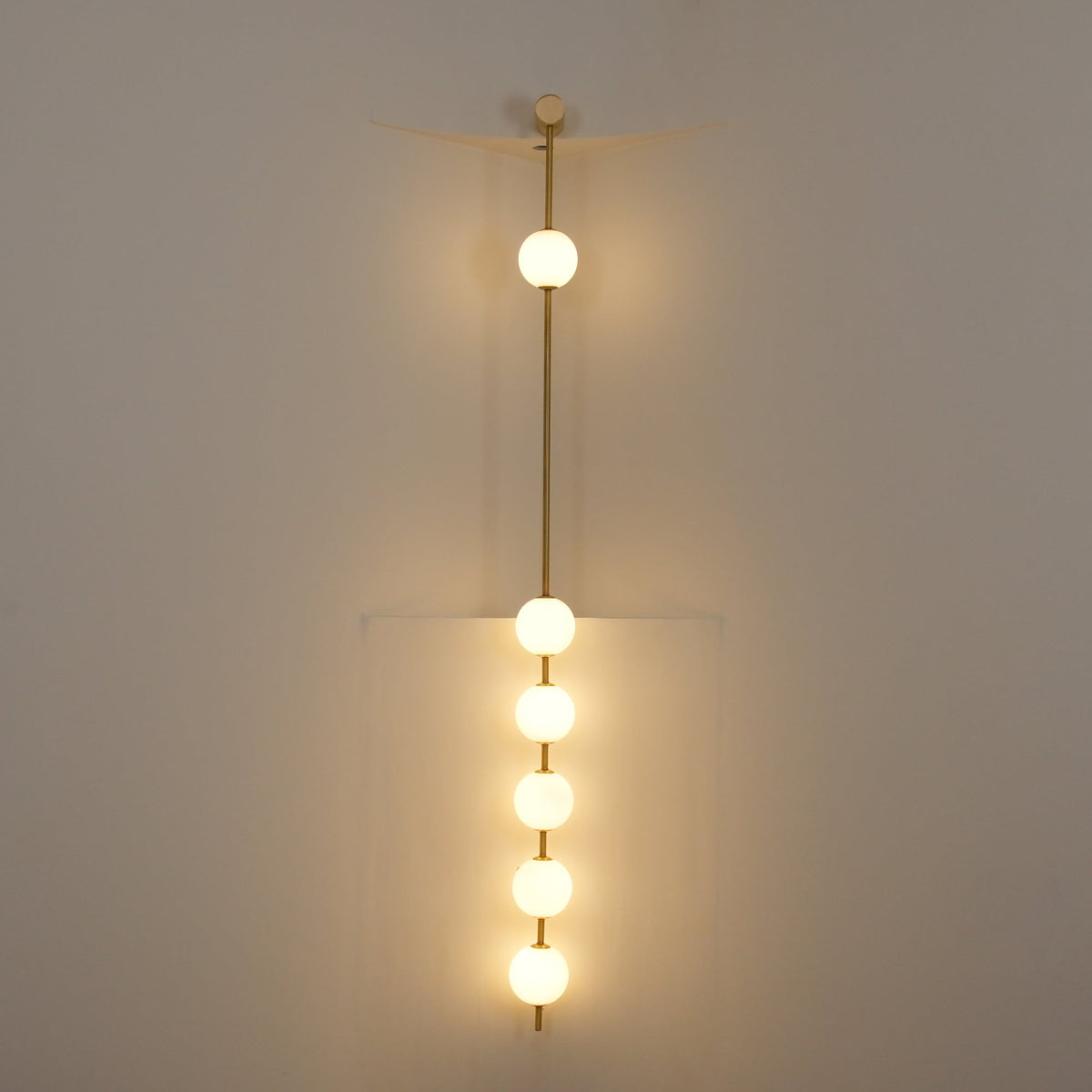 Soloiella wandlamp met verticale bollen van messing