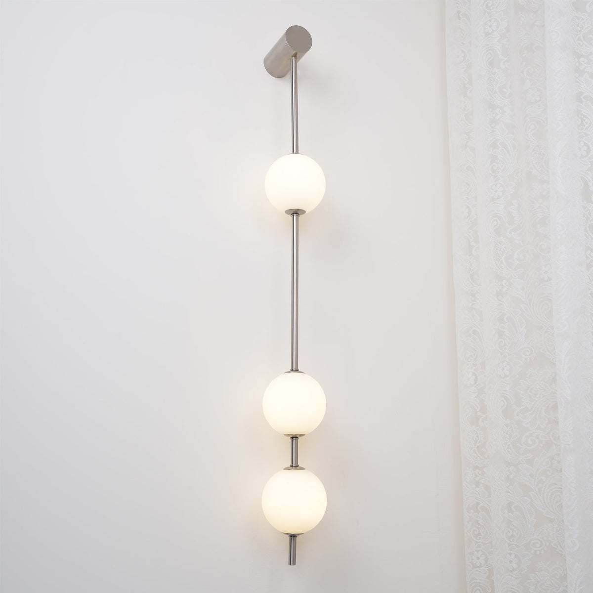 Soloiella wandlamp met verticale bollen van messing