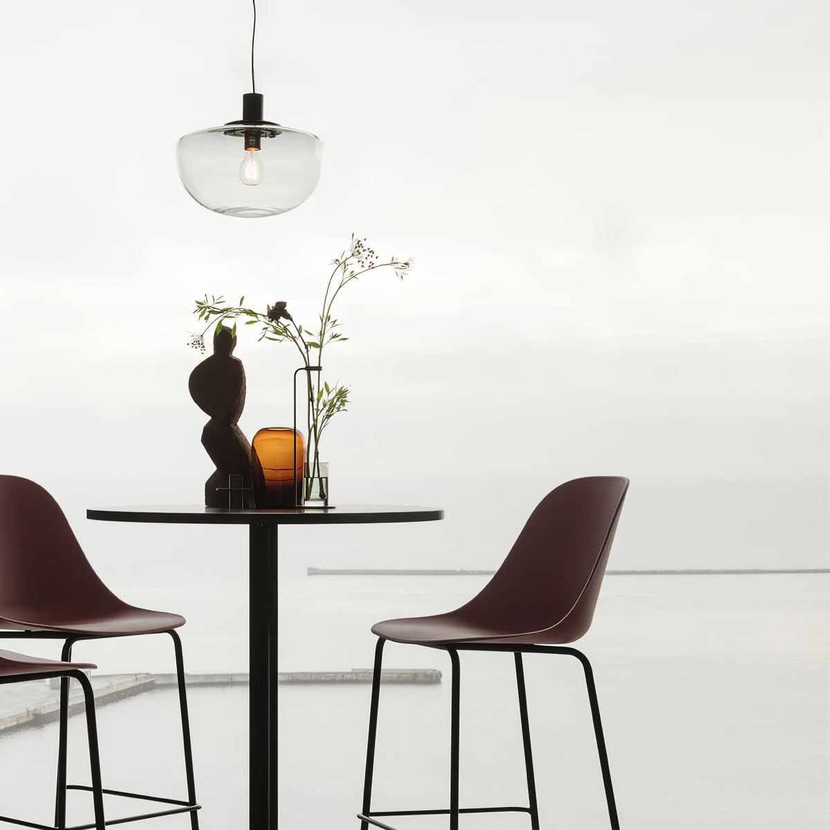 Moderne hanglamp met glazen koepel en metalen bevestiging in minimalistisch ontwerp