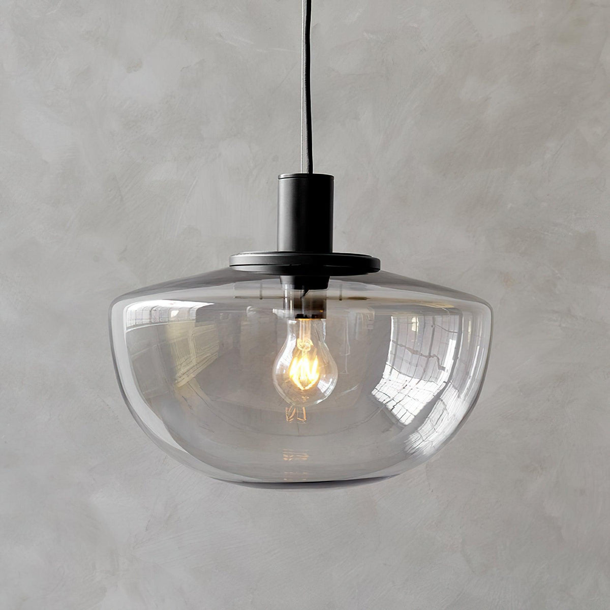 Moderne hanglamp met glazen koepel en metalen bevestiging in minimalistisch ontwerp