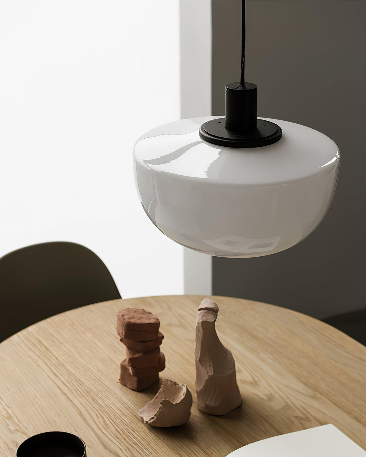 Moderne hanglamp met glazen koepel en metalen bevestiging in minimalistisch ontwerp