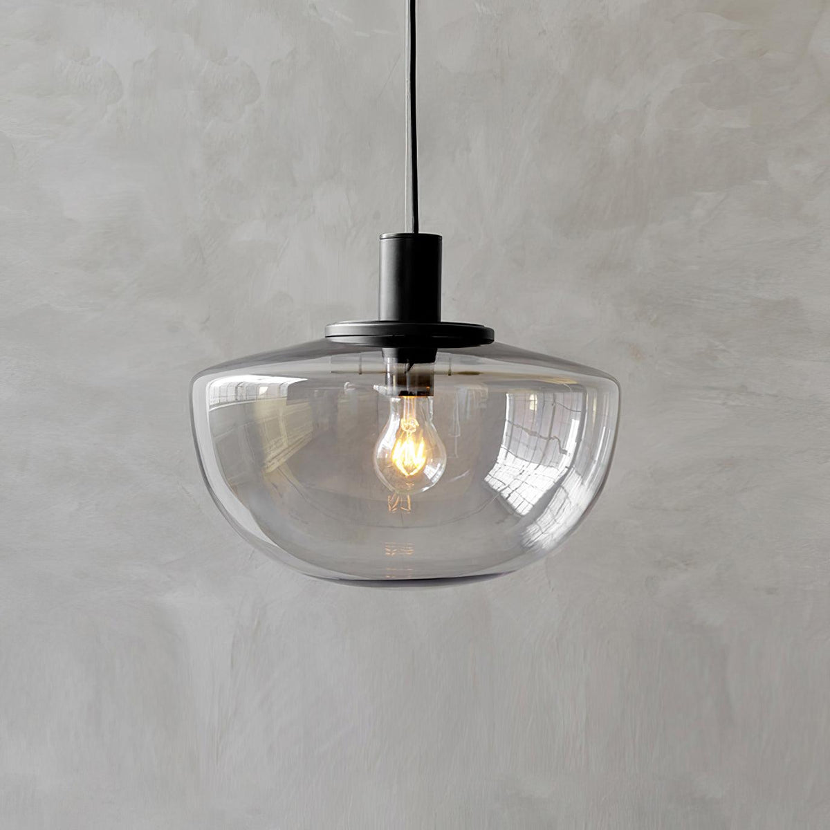 Moderne hanglamp met glazen koepel en metalen bevestiging in minimalistisch ontwerp