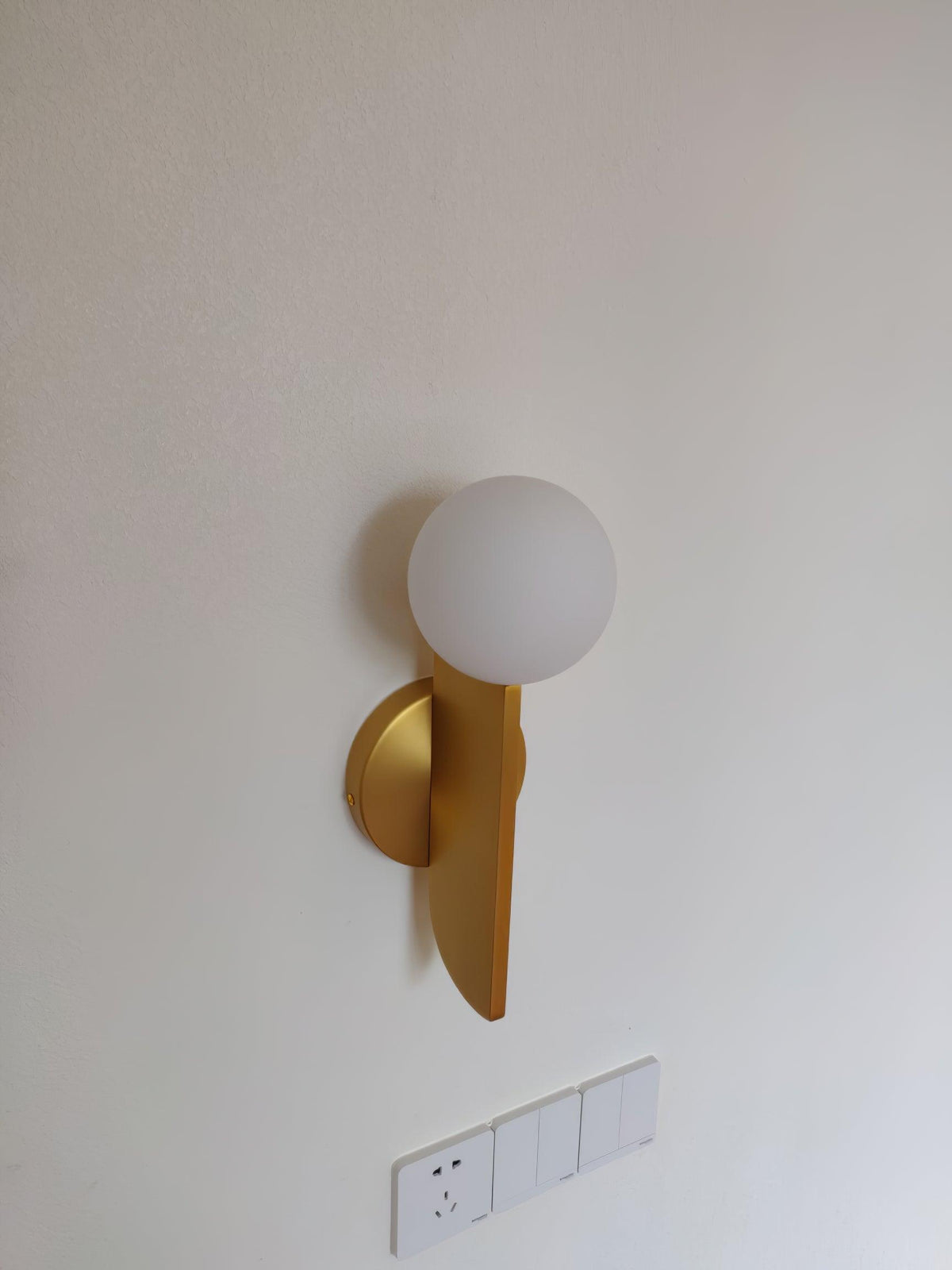 Liorarelle wandlamp met glazen bol en sculpturale vormgeving