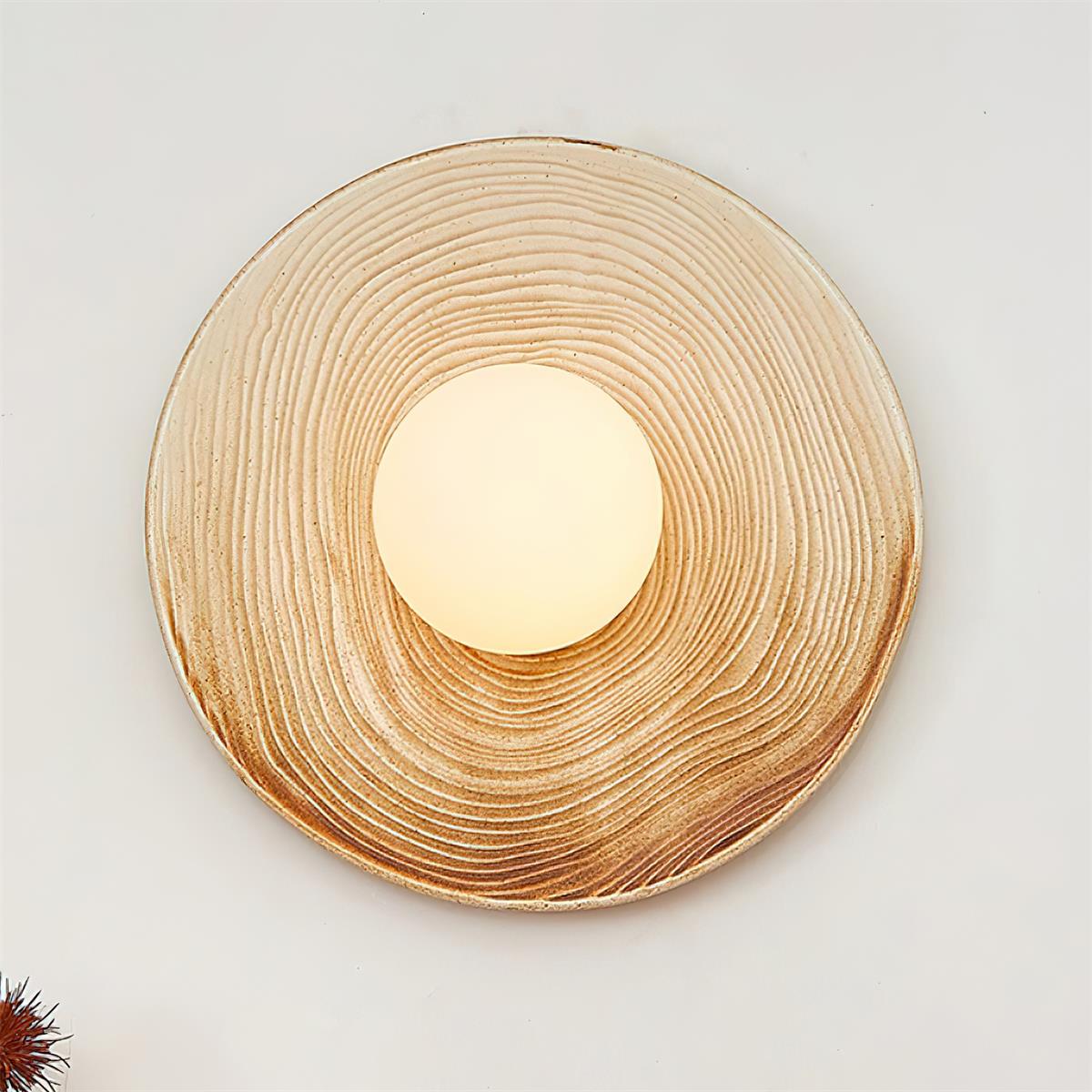 Moderne wandlamp met textuurkeramische schijf en houten accent voor entrees