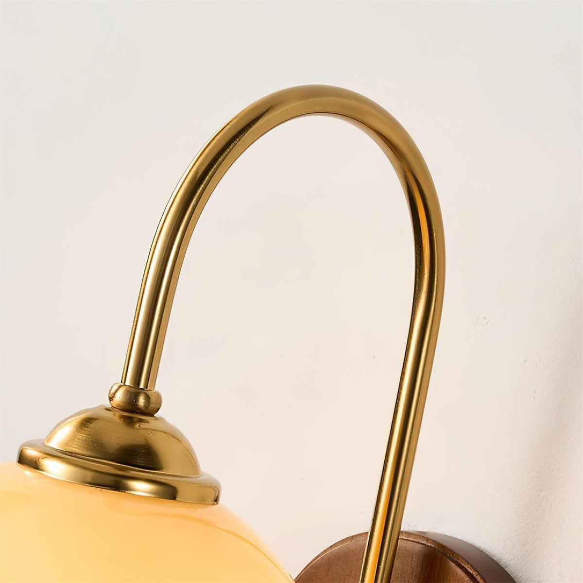 Wandlamp van metaal en glas met gladde bolvormige kap en houten achterplaat