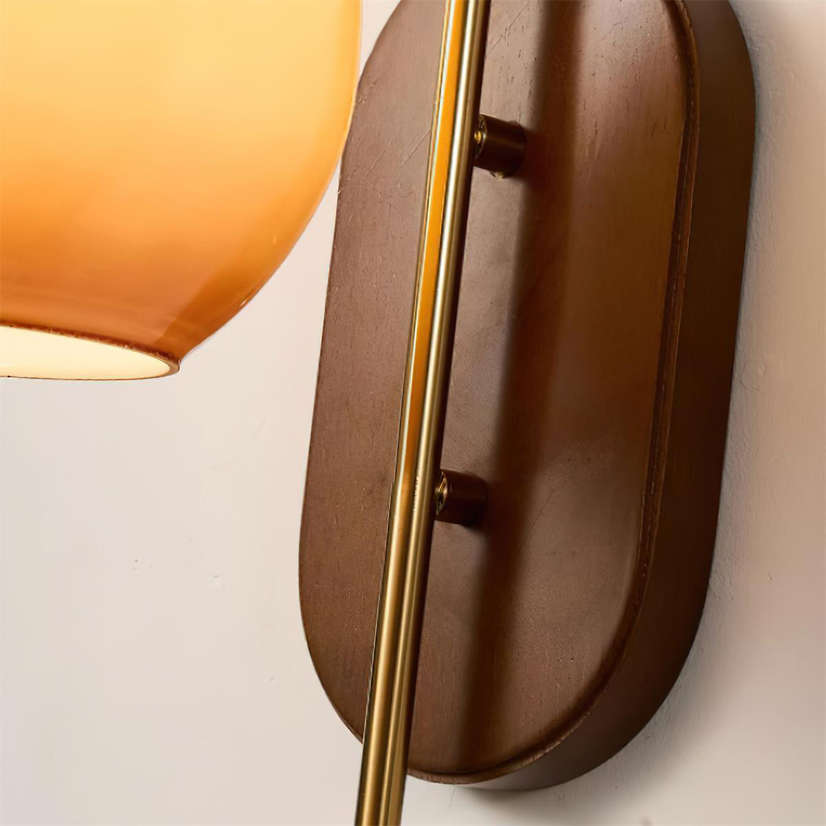 Wandlamp van metaal en glas met gladde bolvormige kap en houten achterplaat