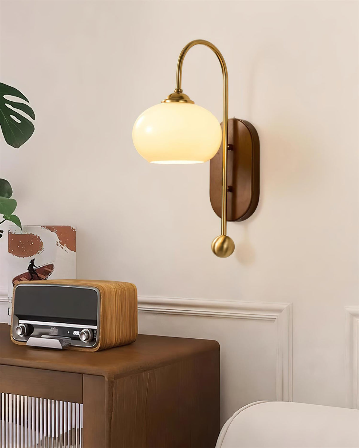 Wandlamp van metaal en glas met gladde bolvormige kap en houten achterplaat