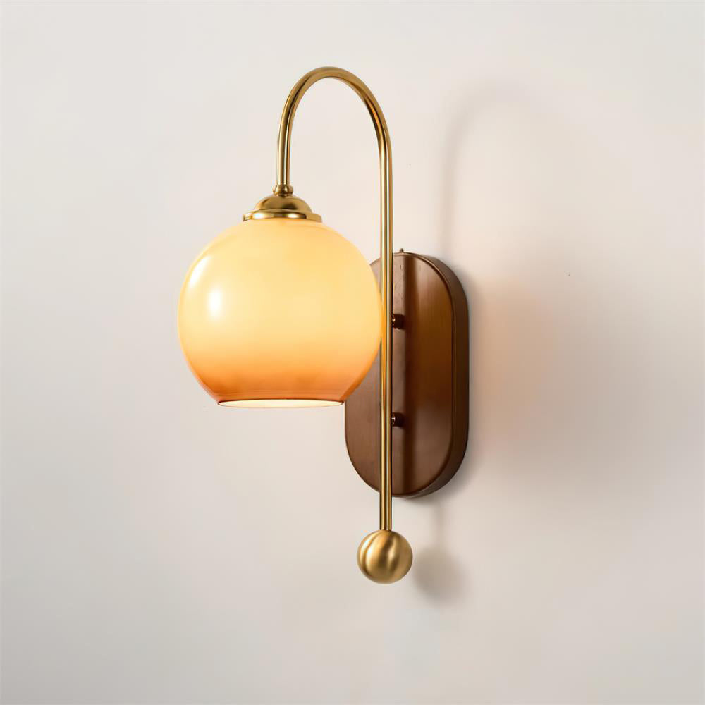 Wandlamp van metaal en glas met gladde bolvormige kap en houten achterplaat