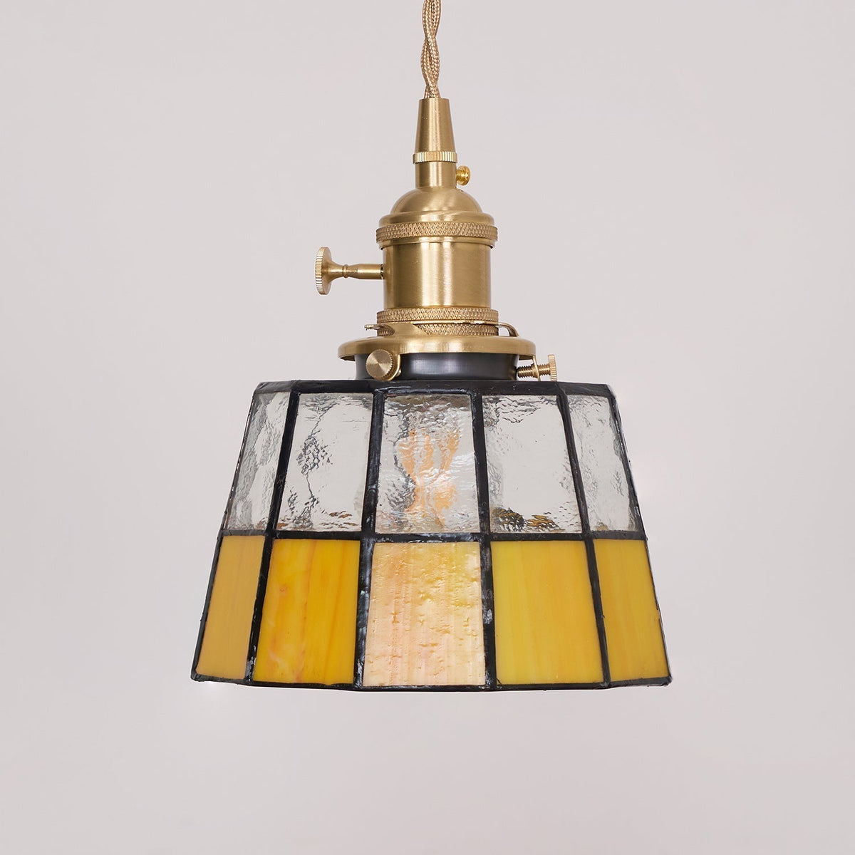 Hanglamp met verkleurd glazen kap in vintage patroon van messing