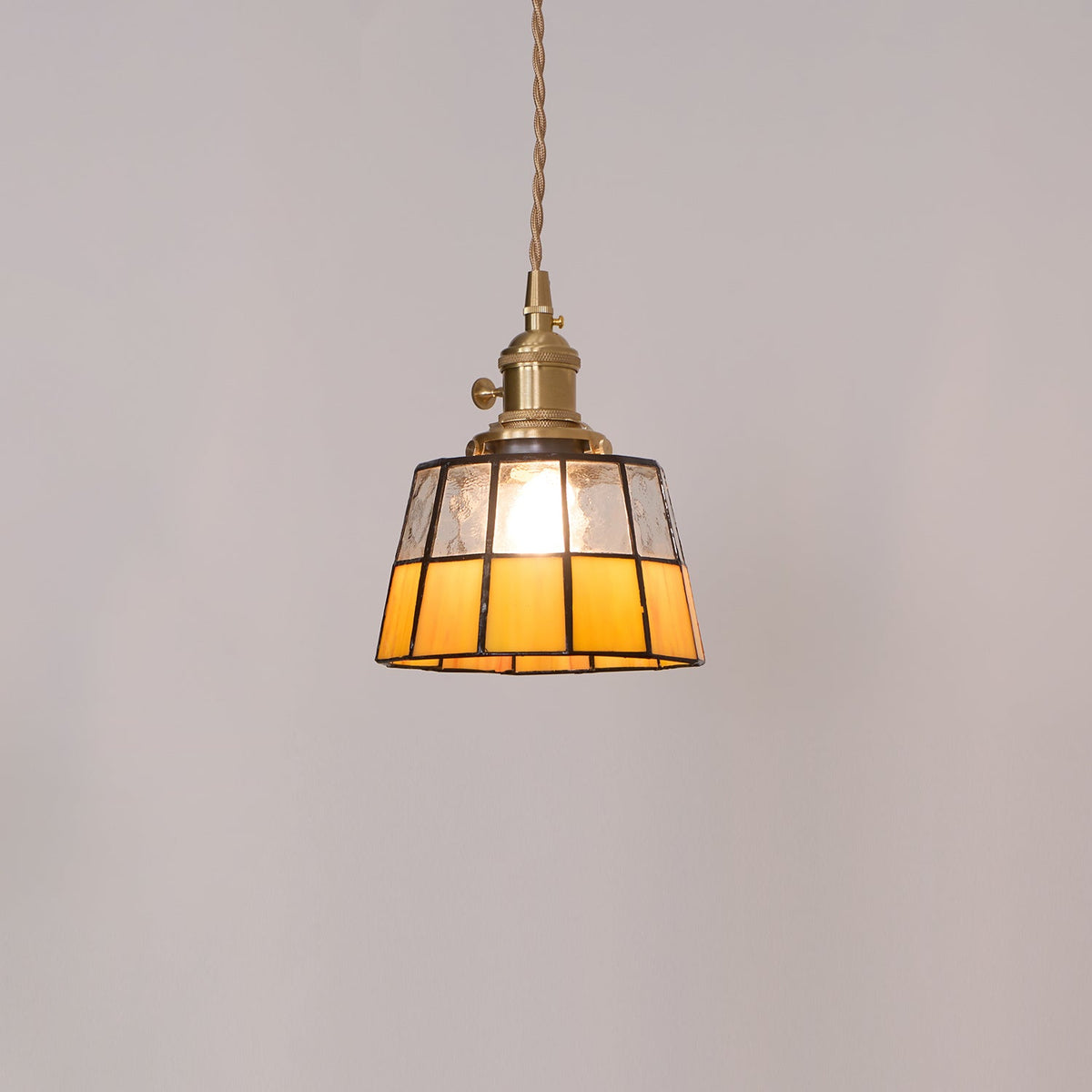 Hanglamp met verkleurd glazen kap in vintage patroon van messing