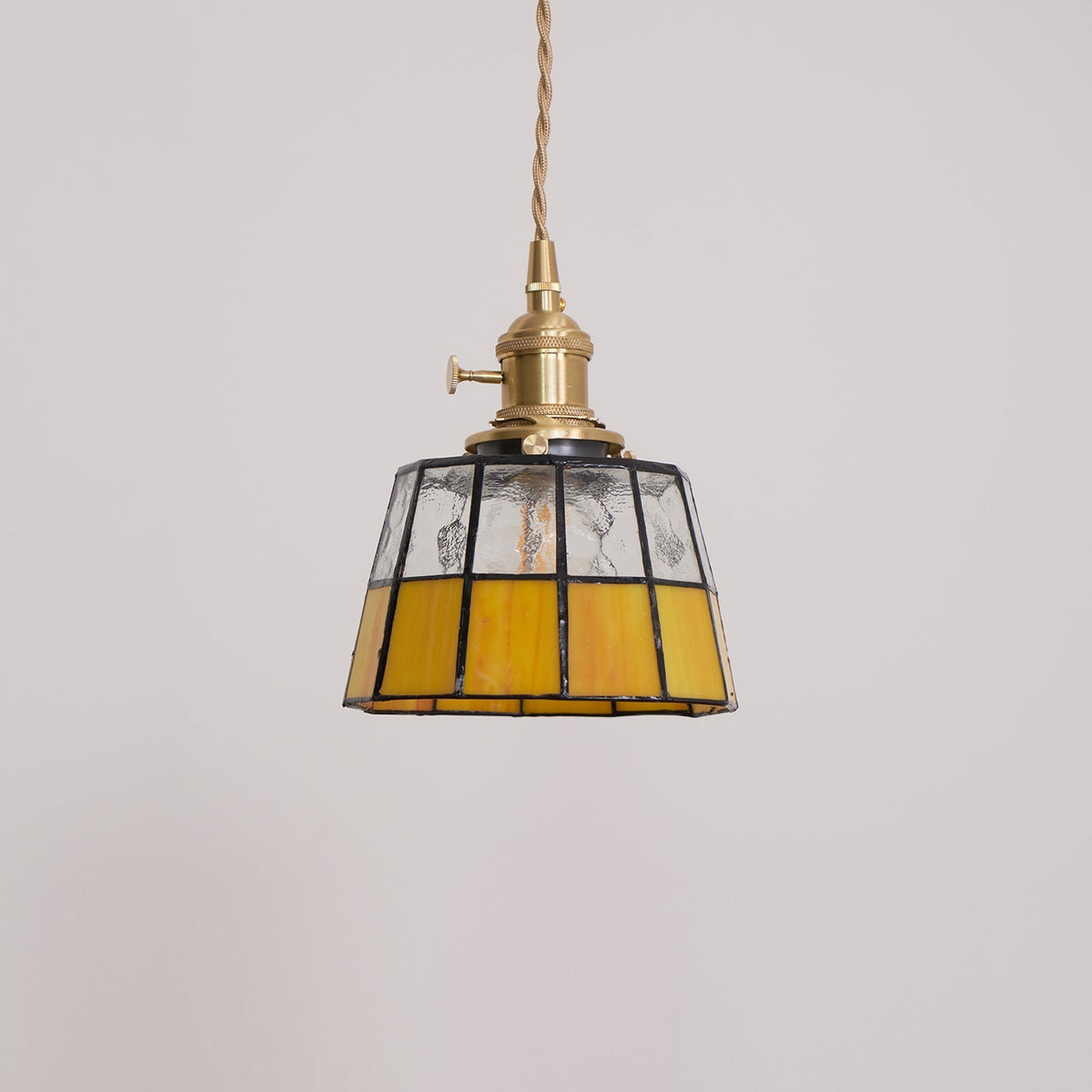 Hanglamp met verkleurd glazen kap in vintage patroon van messing