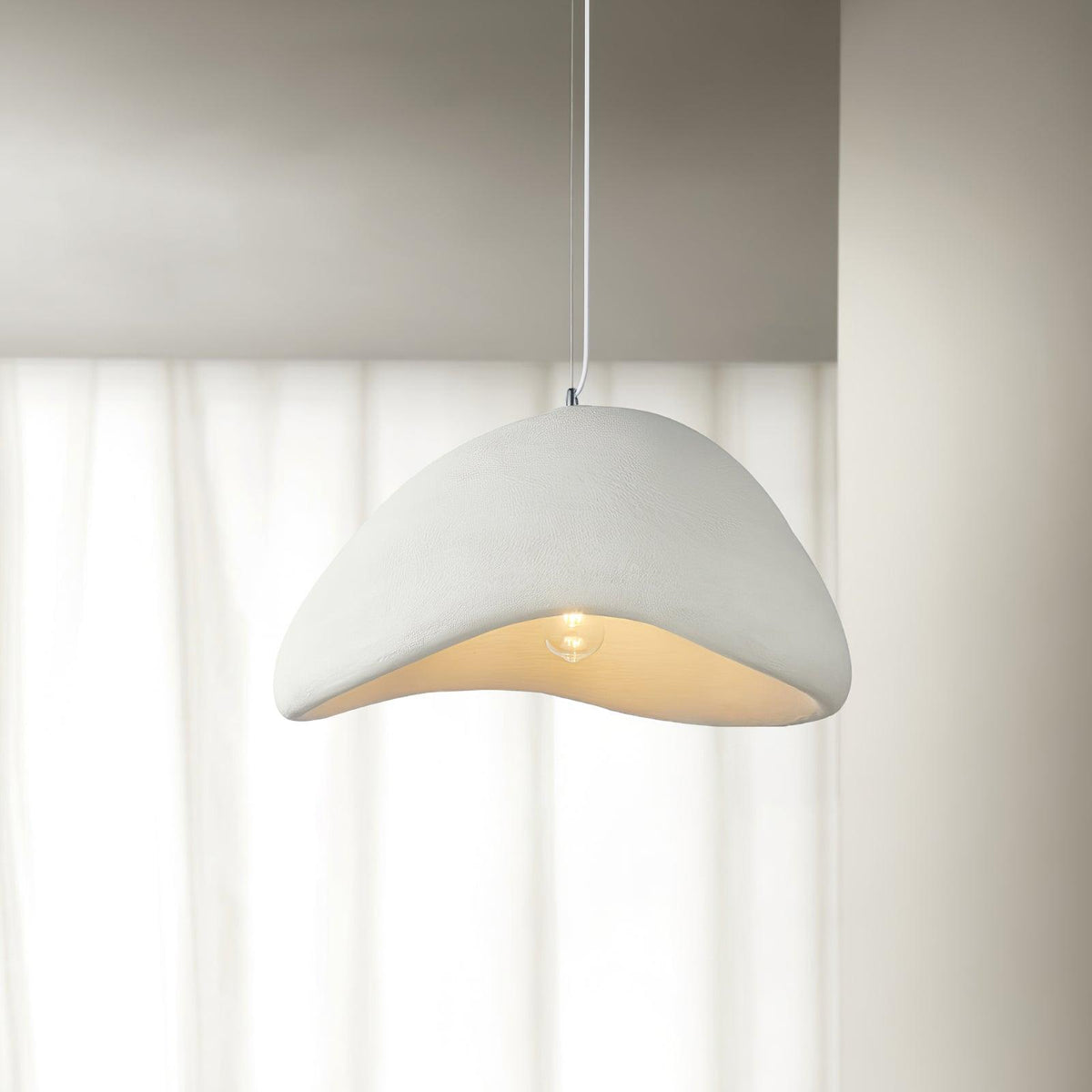 Moderne hanglamp met organische gebogen kap, zachte textuur en artistiek ontwerp