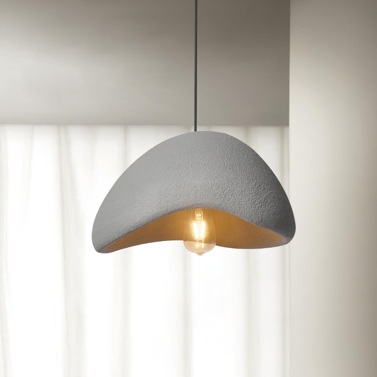 Moderne hanglamp met organische gebogen kap, zachte textuur en artistiek ontwerp