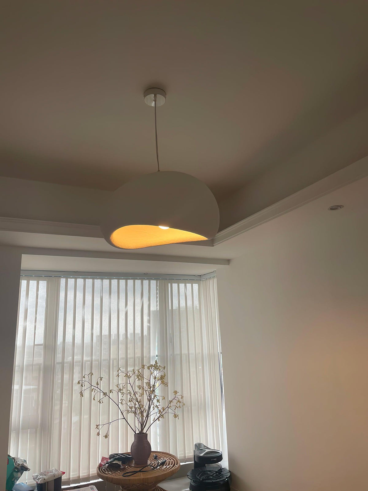 Moderne hanglamp met organische gebogen kap, zachte textuur en artistiek ontwerp