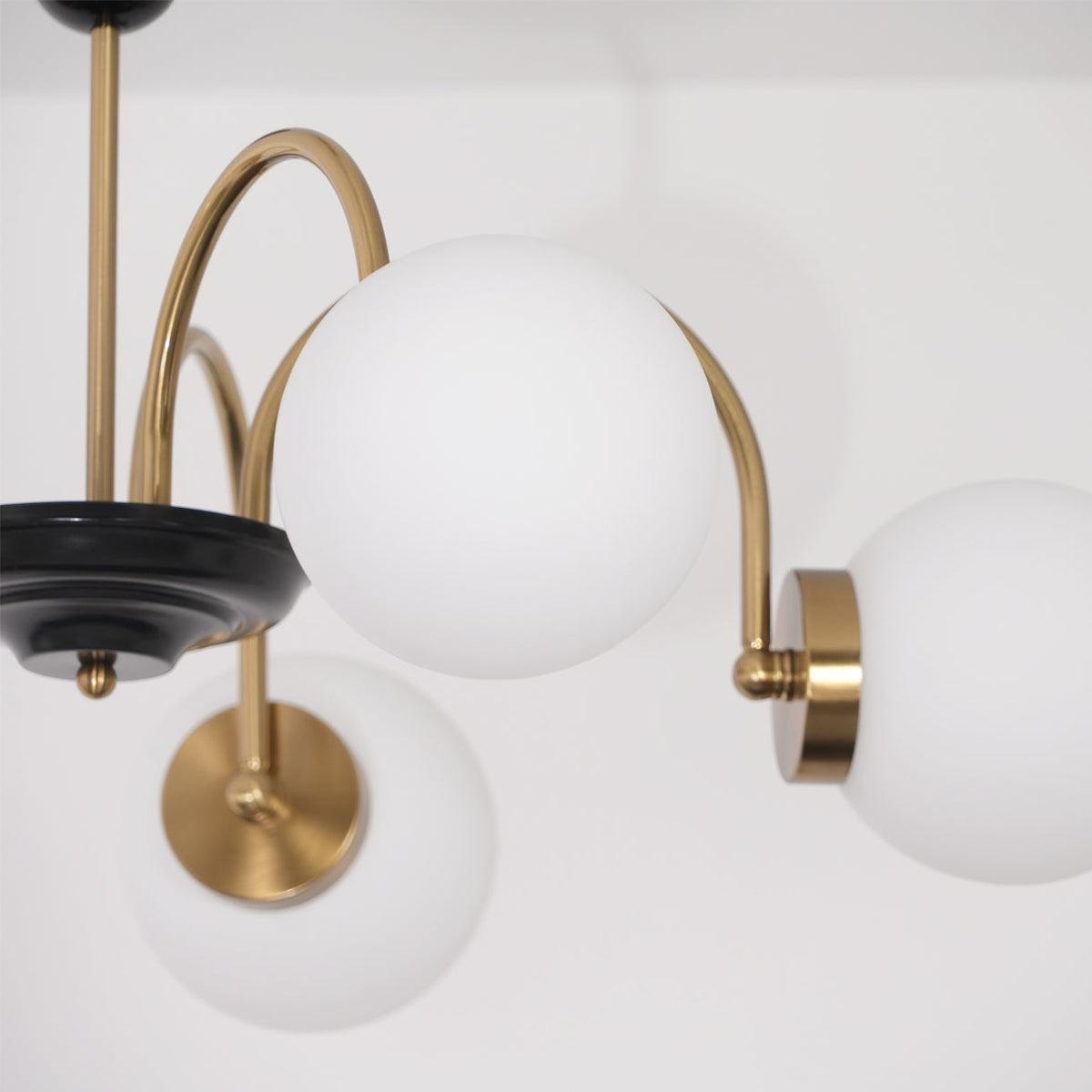 Moderne kroonluchter met gebogen armen en bolvormige kapjes, retro stijl voor eetkamer