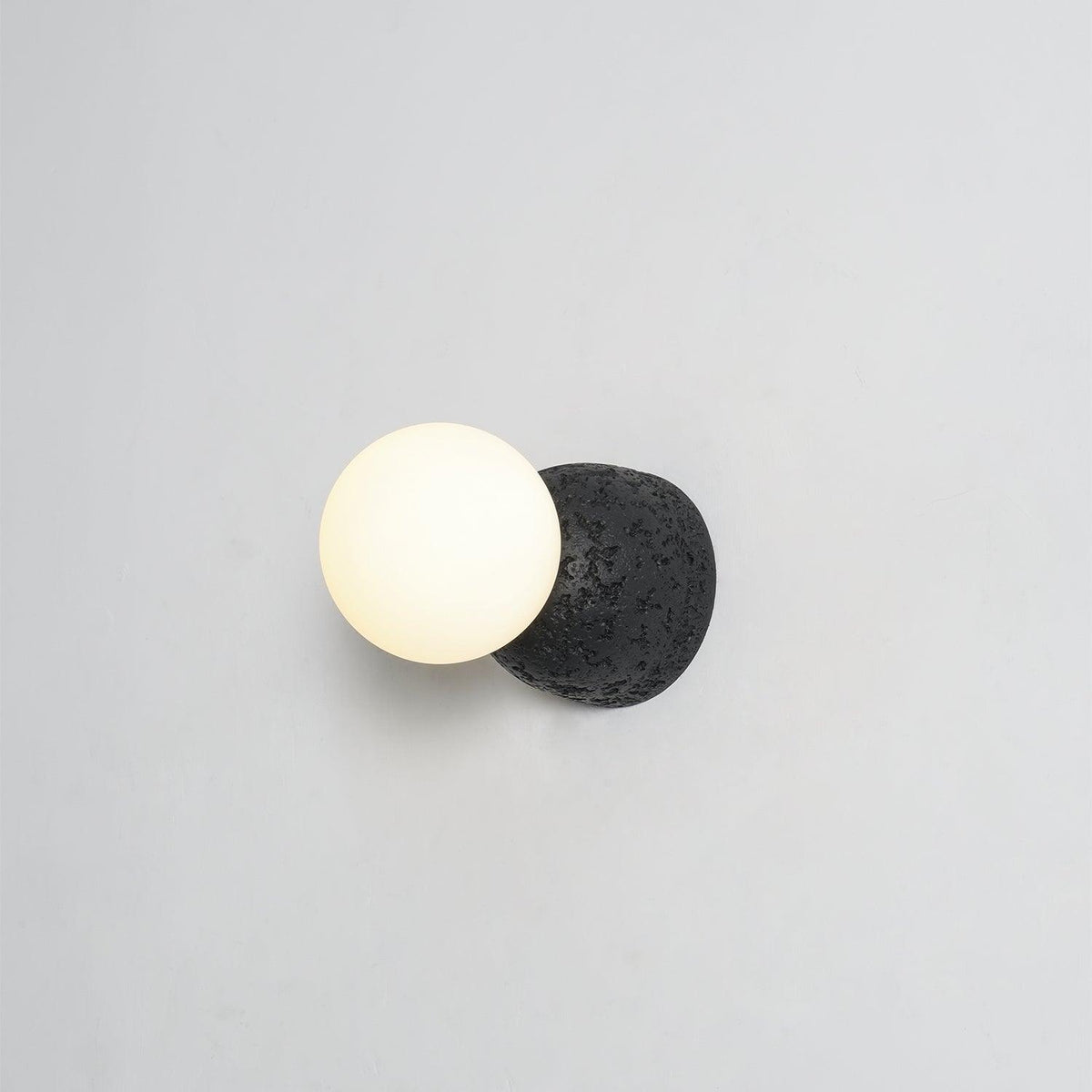 Eirinise wandlamp van beton en melkglas