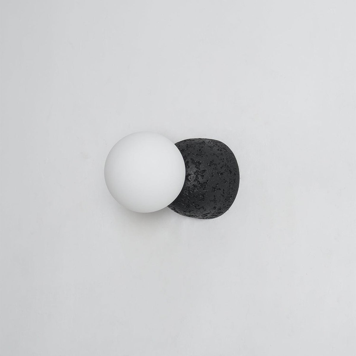 Eirinise wandlamp van beton en melkglas