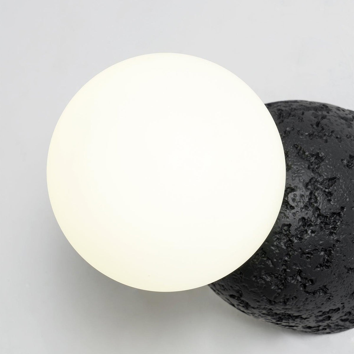 Eirinise wandlamp van beton en melkglas