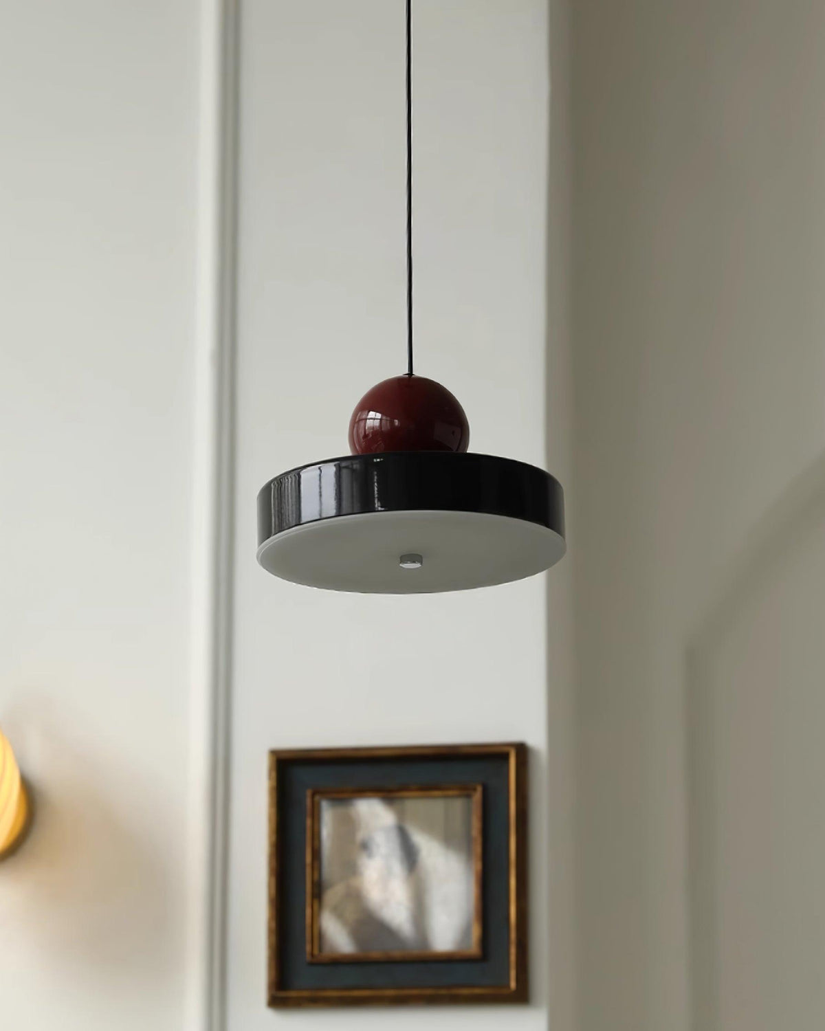 Moderne hanglamp met metalen behuizing, rode bolvormige kap en retro accent