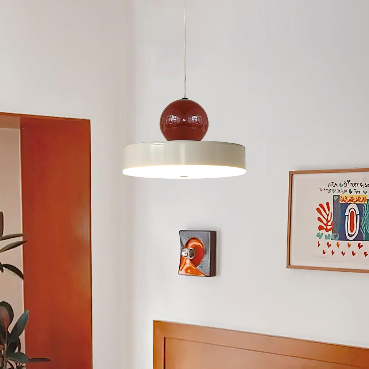 Moderne hanglamp met metalen behuizing, rode bolvormige kap en retro accent