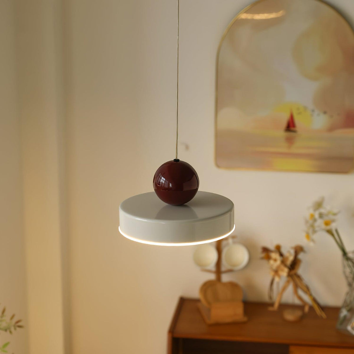 Moderne hanglamp met metalen behuizing, rode bolvormige kap en retro accent