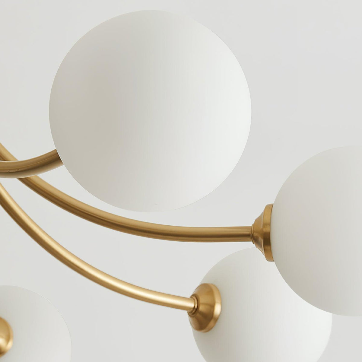 Moderne elegante plafondlamp met vertakte messing armen en opalen bolkappen
