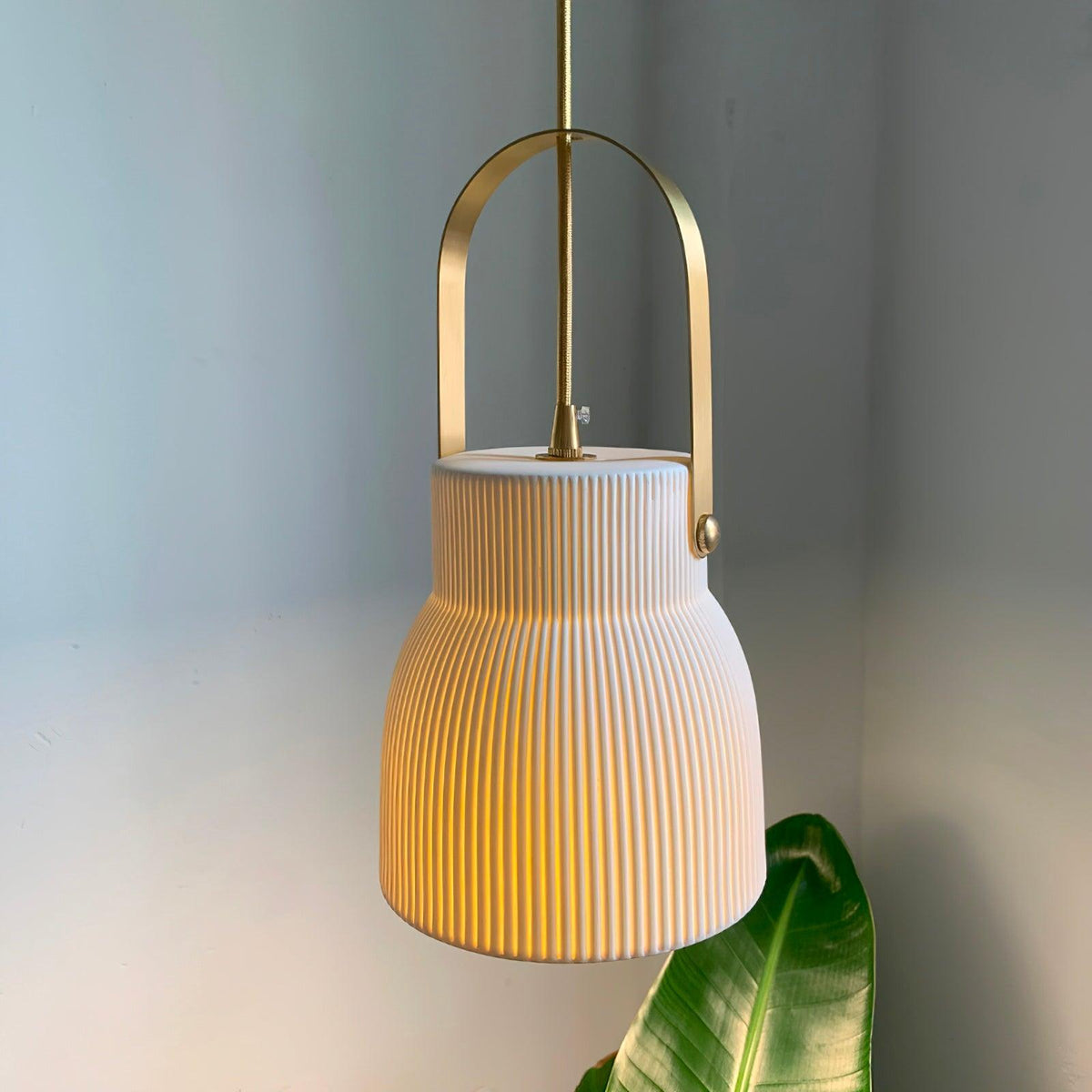 Hanglamp met ribbelstructuur in wit keramiek en messing handvat