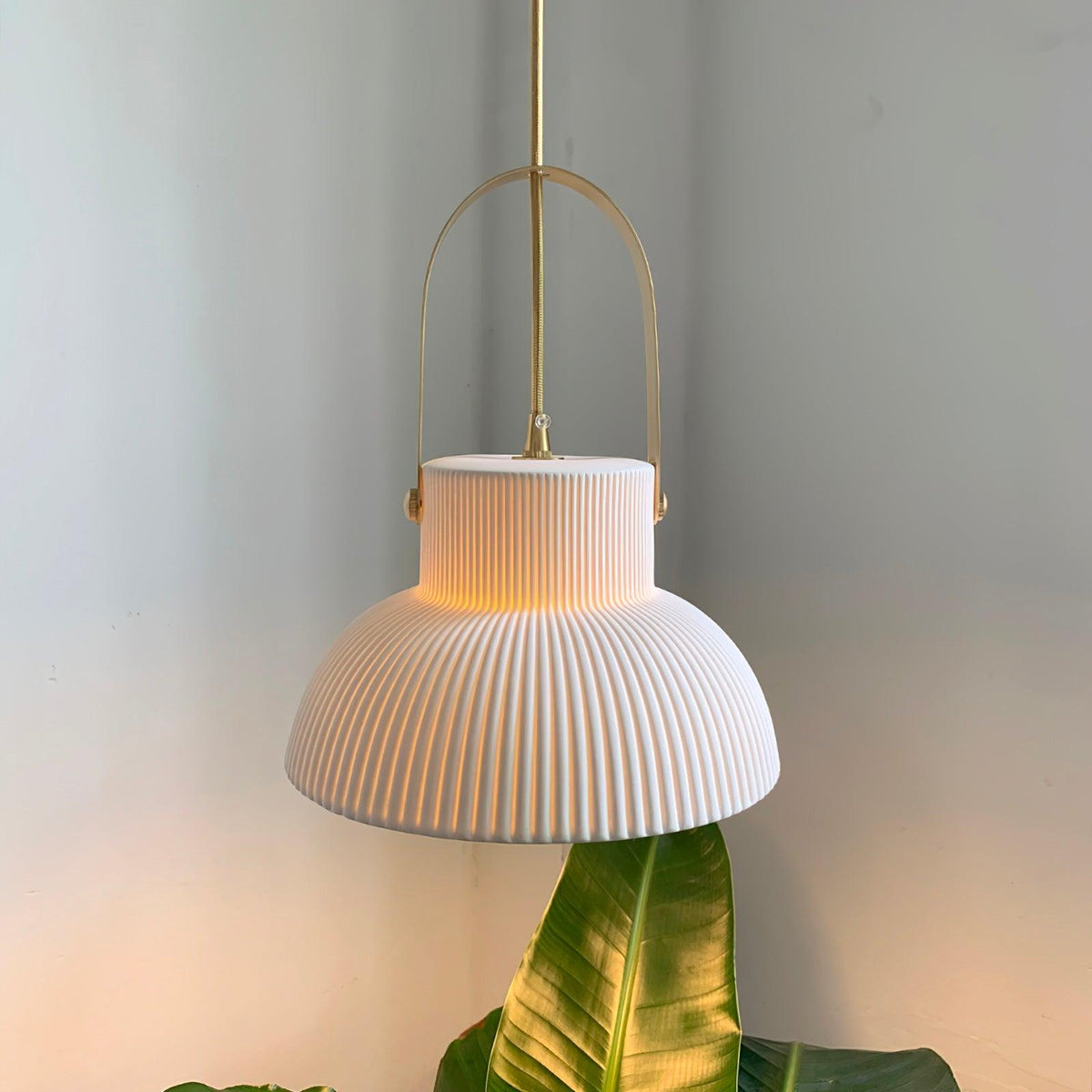 Hanglamp met ribbelstructuur in wit keramiek en messing handvat