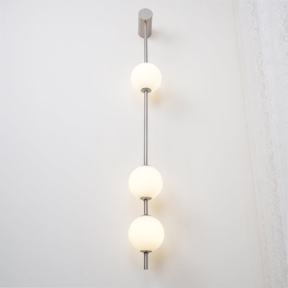 Soloiella wandlamp met verticale bollen van messing